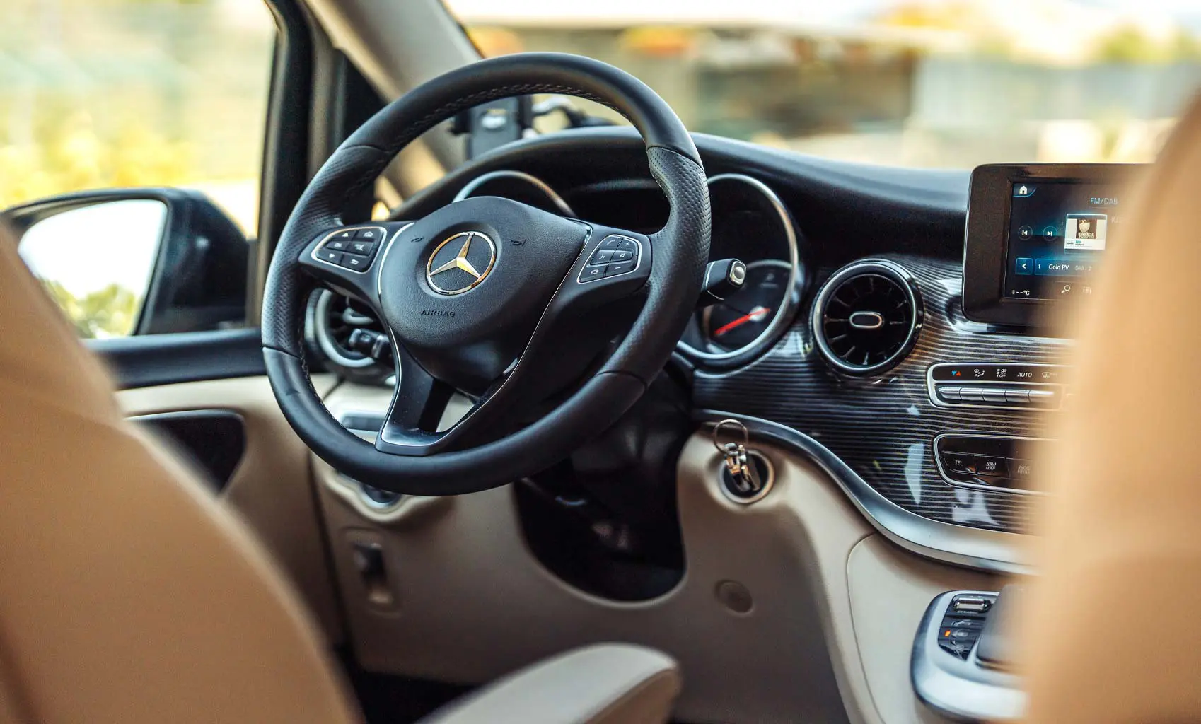 Cruscotto e volante Mercedes in un minivan NCC con interni chiari e finiture eleganti